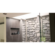 Moderne Badezimmerdusche mit JEE-O Pure Dusche 01, Regenduschkopf, Natursteinfliesen und eingelassener Nische mit Ablagebereich.