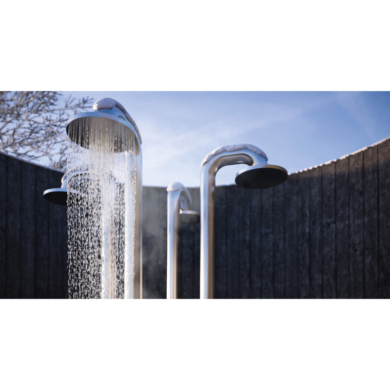 Außendusche JEE-O Fatline Push mit aktivem Wasserschauer vor Holzzaun, strahlend blauer Himmel
