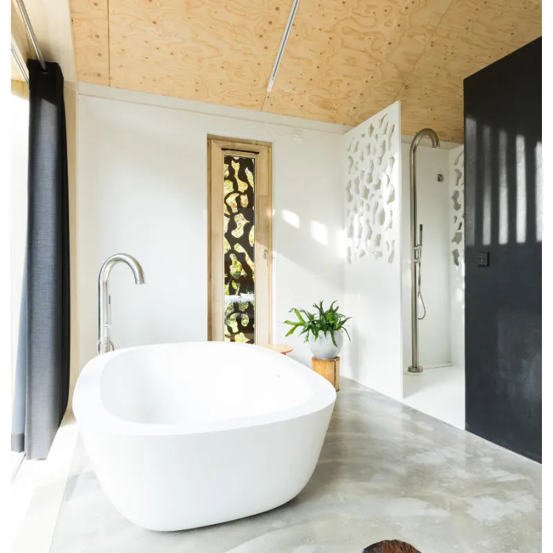 Modernes Badezimmer mit freistehender weißer Wanne und silberner JEE-O Original Standarmatur, Duschbereich mit Glaswand und Korkdecke