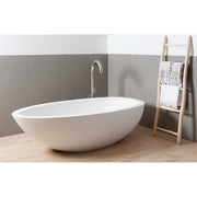 Freistehende weiße Badewanne mit eleganter Kurvenform und chromfarbener JEE-O Standarmatur in modernem Badezimmer mit Holzleiter und weißen Handtüchern