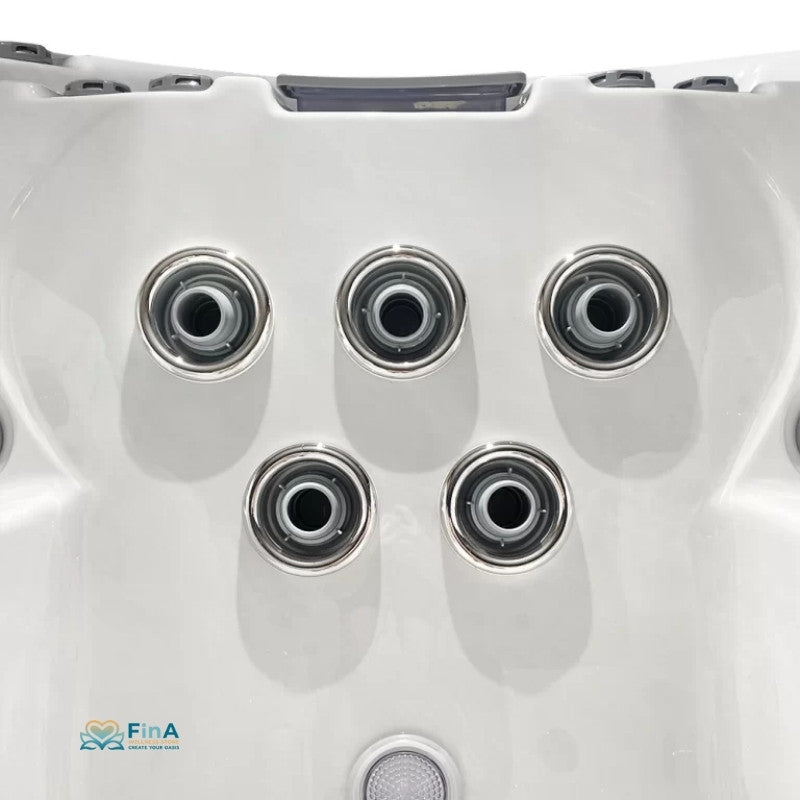 Draufsicht auf die fünf Düsen der JJSpa Beta 6151 Swim Spa mit verchromten Ringen auf weißem Kunststoff und FinA-Logo