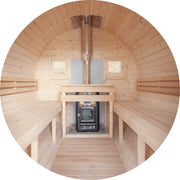 Innenansicht der Koba Basic Fass Gartensauna aus Fichte mit Holzbänken, Saunaofen und Edelstahlschornstein, Blick zum Eingangsbereich