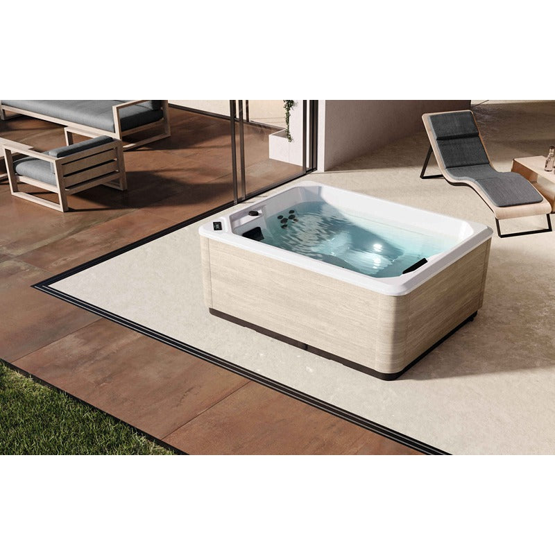 Novellini VITA Outdoor Whirlpool mit heller Schürzenverkleidung im überdachten Terrassenbereich