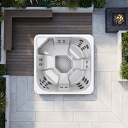 Draufsicht auf weißen Novitek S-0 Outdoor Whirlpool mit achteckiger Form, Massagedüsen und zentralem Becken auf Terrassenplatz mit Holzdeck und Natursteinbelag