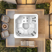 Novitek S-1 Outdoor Whirlpool mit weißem Kunststoffgehäuse und mehreren Massagedüsen, von oben fotografiert in moderner Terrasse mit Holzdecking, Pflanzenkübeln und Loungemöbeln