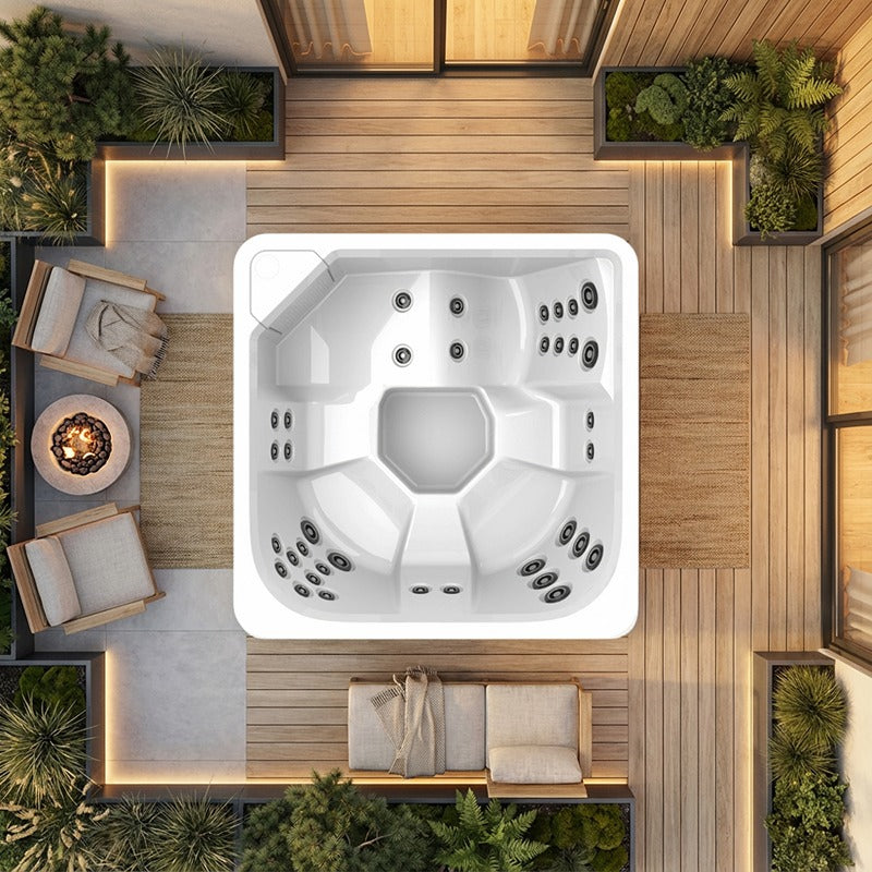 Novitek S-1 Outdoor Whirlpool mit weißem Kunststoffgehäuse und mehreren Massagedüsen, von oben fotografiert in moderner Terrasse mit Holzdecking, Pflanzenkübeln und Loungemöbeln