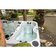 Zwei weiße Eisbäder mit sprudelndem Wasser im Gartenbereich, umgeben von Pflanzkübeln und Natursteinen, Passion Spas Elevate Modell