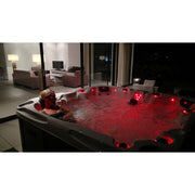 Passion Spas Pleasure Outdoor Whirlpool bei Nacht mit roter LED-Beleuchtung und sprudelndem Wasser