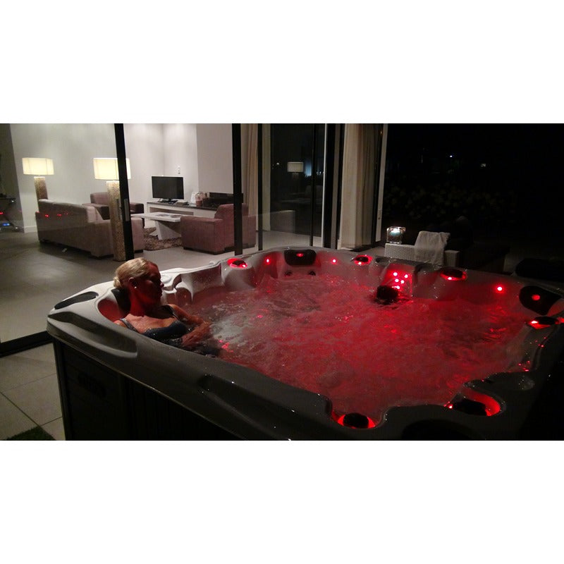 Passion Spas Pleasure Outdoor Whirlpool bei Nacht mit roter LED-Beleuchtung und sprudelndem Wasser