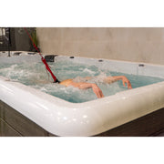  Frau trainiert im Swim Spa mit Schwimmseil – dynamische Kraulbewegung bei konstantem Wasserwiderstand