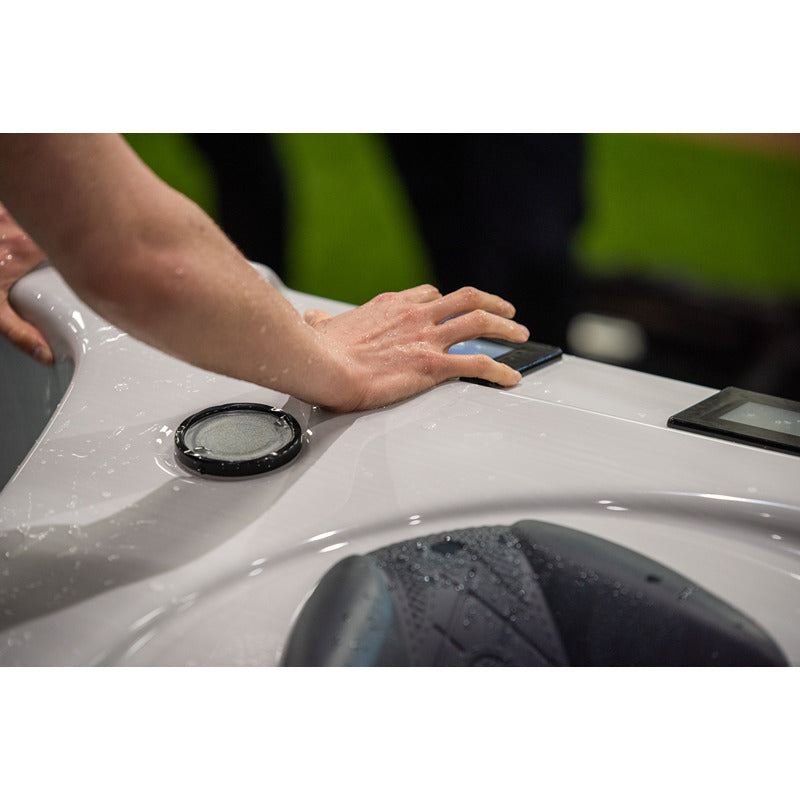  Nutzerin bedient das Touchpanel am Swim Spa – ergonomische Bedienung auch bei Wassereinwirkung