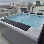 Innenansicht des Platinum Spas Lounge Divine Outdoor Whirlpool 220x190x80 mit zwei Liegen und Meerblick