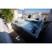 Stilvoller Whirlpool Platinum Spas Topaz – Premium auf Dachterrasse mit Ausblick über die Stadt. Wasser sprudelt bei eingeschaltetem Betrieb