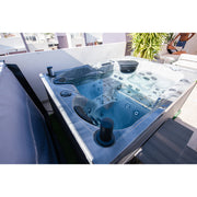 Platinum Spas Topaz Outdoor Whirlpool mit blauem Wasser, mehreren Düsen und Kontrollelementen auf sonniger Terrasse installiert.