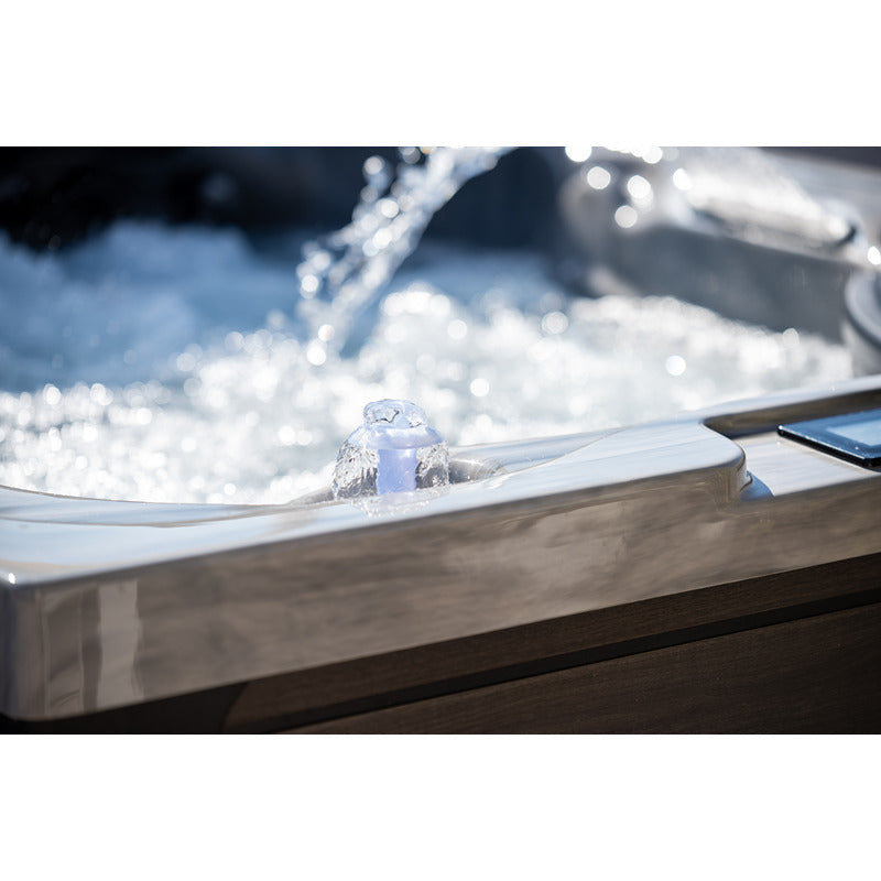 Nahaufnahme eines beleuchteten Wasserbrunnens im Platinum Spas Topaz Outdoor Whirlpool – Premium mit sprudelndem Wasser.
