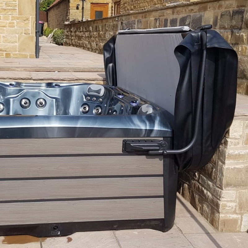 VX2 Cover Lifter in Anwendung – gefaltete Abdeckung an Whirlpool mit grauer Außenverkleidung vor Steinmauer