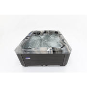 Platinum Spas Refresh Outdoor Whirlpool – mit sprudelndem Wasser und aktivierten Massagedüsen. Ansicht schräg von vorne mit hoher Sprudelaktivität