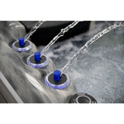 Detailaufnahme des Platinum Spas Refresh Outdoor Whirlpool – drei Wasserfontänen mit blauer LED-Beleuchtung und elegantem Rand in Marmoroptik