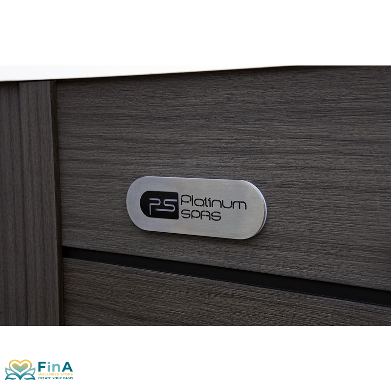 Nahaufnahme des Platinum Spas Logos auf der anthrazitfarbenen Außenverkleidung des St Tropez Deluxe Whirlpools – gebürstetes Metallschild auf Holzstruktur, präsentiert von FinA Wellness Store.