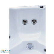 Nahaufnahme des Platinum Spas St Tropez Deluxe Whirlpools – zwei Hydrotherapie-Düsen und LED-Unterwasserlicht im weißen Acrylbecken, dargestellt von FinA Wellness Store.