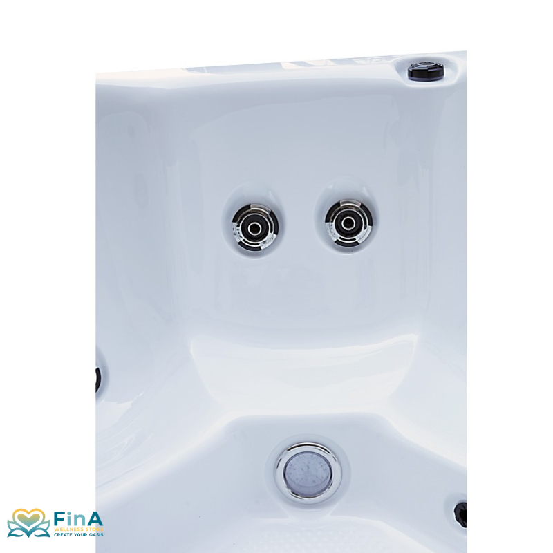 Nahaufnahme des Platinum Spas St Tropez Deluxe Whirlpools – zwei Hydrotherapie-Düsen und LED-Unterwasserlicht im weißen Acrylbecken, dargestellt von FinA Wellness Store.