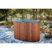 Holz-Eisbad PolarSPA Standard mit grauem Deckel im verschneiten Garten zwischen Bäumen, Thermoholz-Konstruktion in warmer Holzoptik