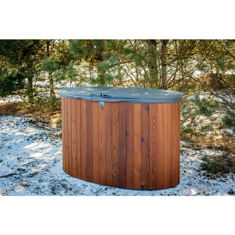 Holz-Eisbad PolarSPA Standard mit grauem Deckel im verschneiten Garten zwischen Bäumen, Thermoholz-Konstruktion in warmer Holzoptik