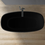 Freistehende ovale Badewanne aus schwarzem Mineralguss EAGO AWT StoneArt BS-552 mit moderner Armatur von oben fotografiert auf Holzboden