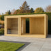 Moderne Gartensauna aus hellem Holz in stilvoller Gartenumgebung mit Natursteinplatten, Ziergräsern und gepflegtem Rasen – elegantes Outdoor-Wellnesskonzept für Zuhause.