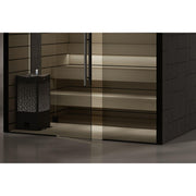 Moderne Infrarotkabine Tylö Reflection mit schwarzem Rahmen, breiten Glastüren und hellen Holzbänken, daneben schwarzer Saunaofen mit Lüftungsgitter