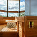 HUUM UKU GLASS Gehäuse – goldfarben, elegant eingebaut in stilvoller Panoramasauna
