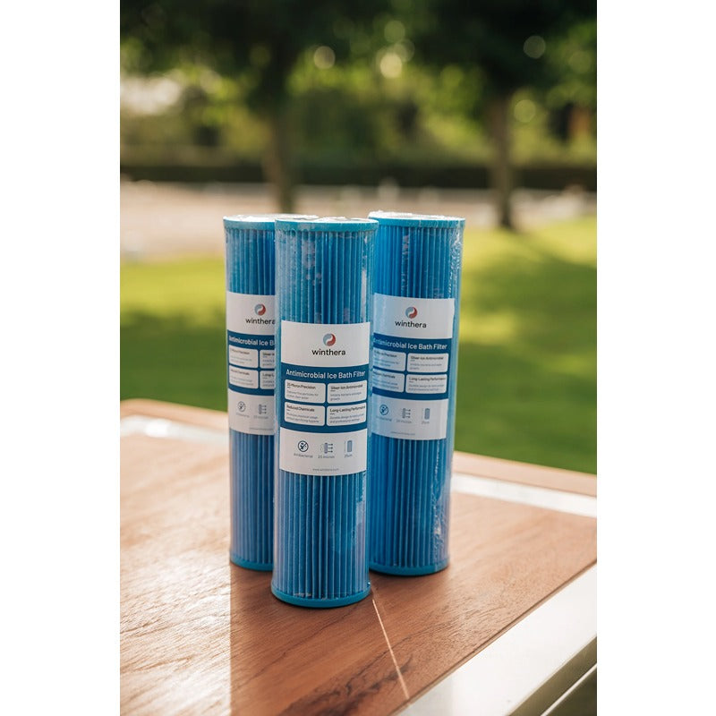 Drei Winthera Antimicrobial Ice Bath Filter stehend auf Holzoberfläche im Freien – hochwertige Wasserfiltration für Eisbäder.