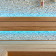 Detailaufnahme der AWT E1601B Sauna mit Rückenlehne aus roter Zeder und indirekter blauer LED-Beleuchtung