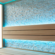 Detailansicht der Naturstein-Rückwand in der AWT E1601B Sauna mit blauer LED-Hintergrundbeleuchtung