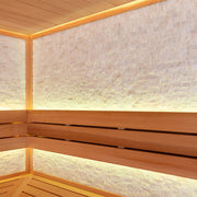 Detailansicht der Natursteinwand und Sitzbänke in der AWT E1603XL Sauna aus roter Zeder mit indirekter Beleuchtung