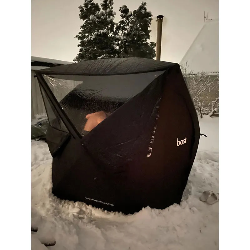 Bast Näver Premium Zeltsauna schwarz im Schnee mit Person, tragbare Gartensauna für 2-6 Personen