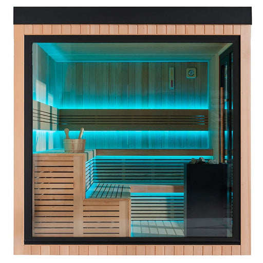 Frontansicht der AWT The Cube X7-L Hemlock Außensauna 300×235 cm mit EOS Cubo Ofen, großer Glasfront und blauer LED-Ambientebeleuchtung