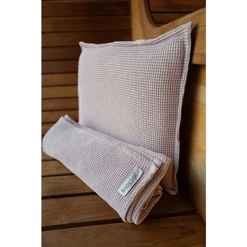 Badesofa Kopfkissen und Saunatuch Set in Rose aus Bio-Waffelpiqué auf einer Holzsaunabank arrangiert