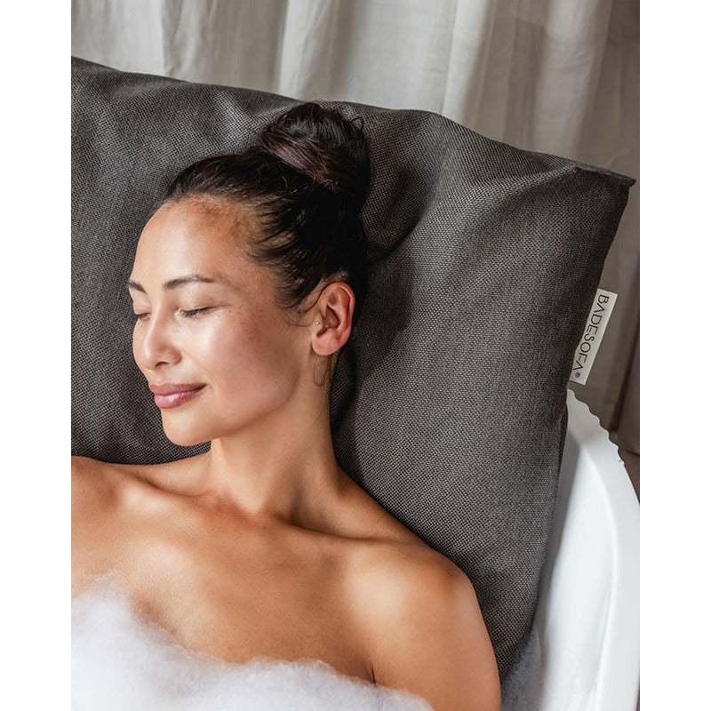 Frau entspannt in der Badewanne mit dunkelgrauem Badesofa Rückenkissen – weiche Polsterung für maximalen Komfort