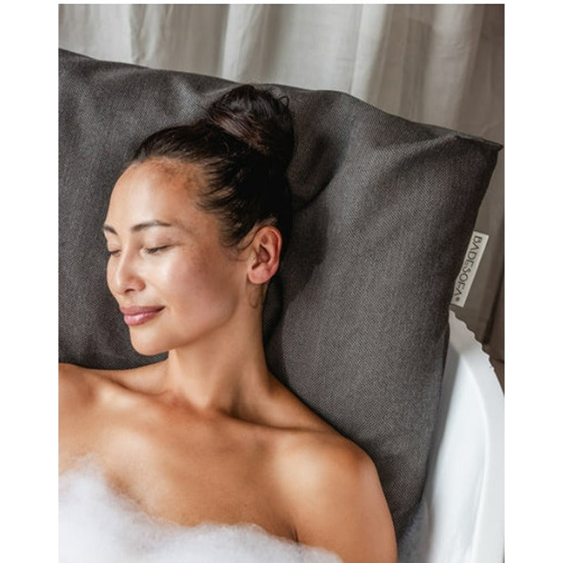 Frau entspannt mit dem BADESOFA Rückenkissen in Anthrazit – ergonomische Unterstützung in stilvollem Design.