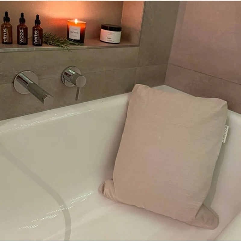BADESOFA Rückenkissen in Beige mit Duftkerze – stilvolle Entspannungsmomente im eigenen Badezimmer.