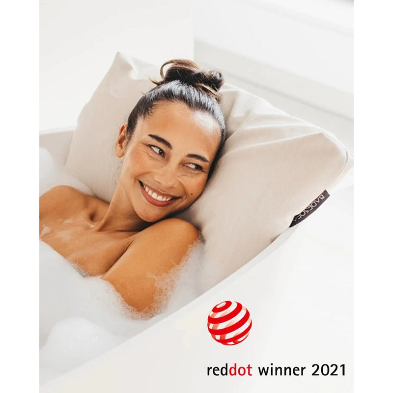 Lächelnde Frau mit beigem Badesofa Rückenkissen in der Badewanne – Red Dot Award Gewinner 2021
