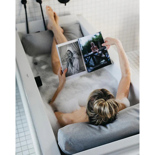 Entspannter Lesemoment mit grauem Badesofa Rückenkissen-Set in der Badewanne – stilvolle Wohlfühloase