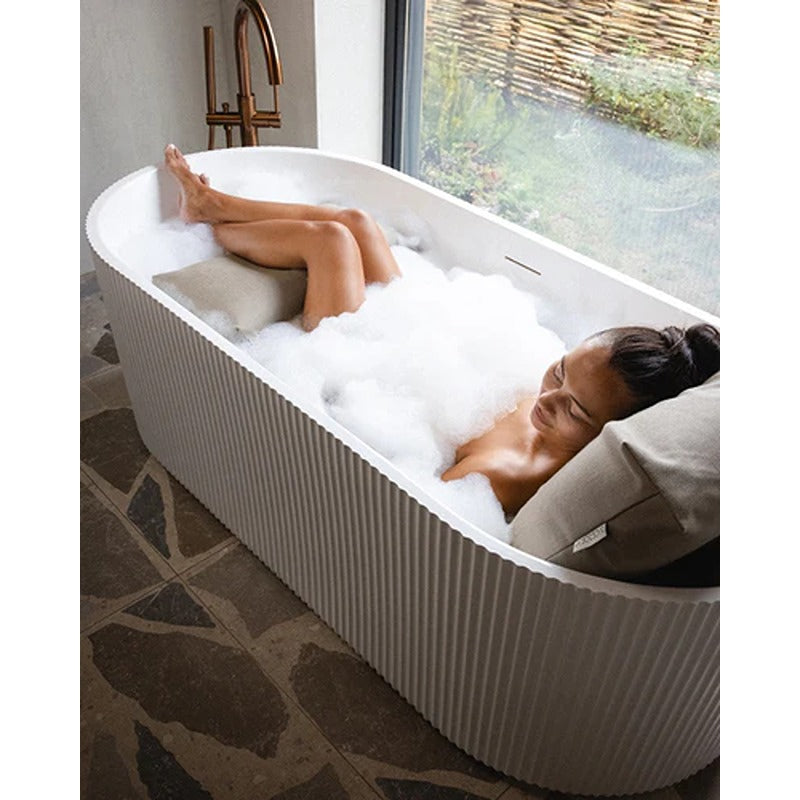 Frau entspannt in moderner Badewanne mit beigem Badesofa Rückenkissen und Fußkissen – luxuriöser Komfort für Zuhause