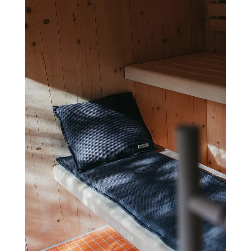 Saunaauflage Short in Blau mit passendem Kissen – dekoriert in Holzsauna