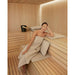 Frau entspannt in der Sauna mit dem Badesofa Saunakissen & Saunatuch Set in Nature aus Bio-Baumwolle
