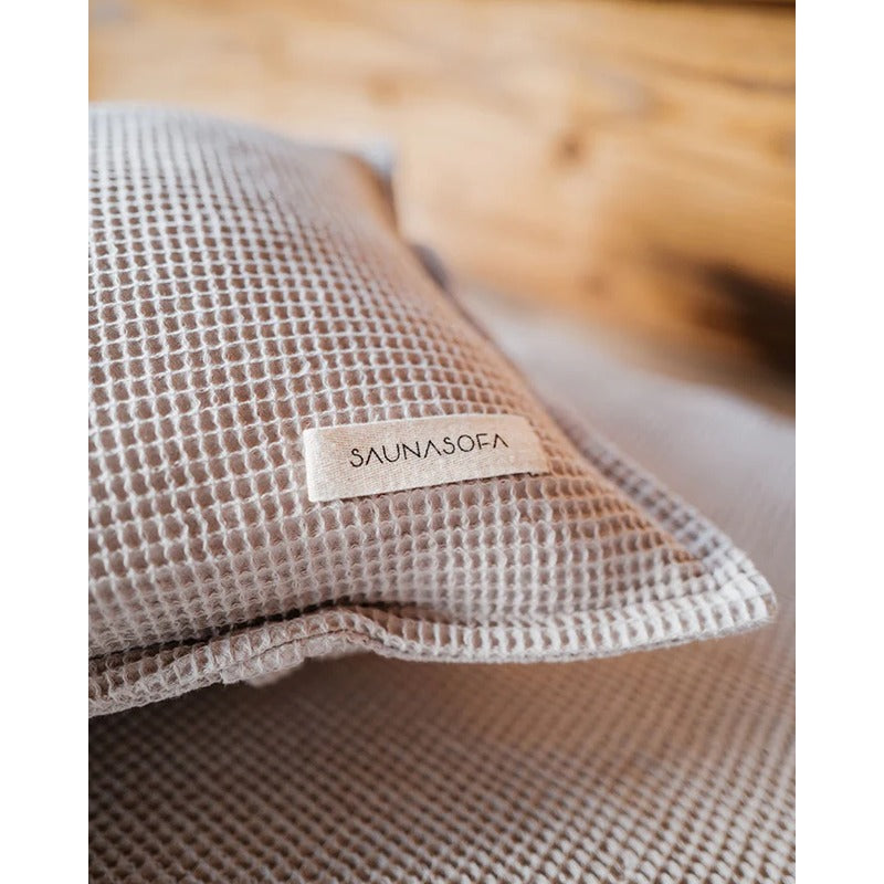 Detailansicht eines Badesofa Saunakissens aus Waffelpiqué mit sichtbarem Markenlabel „SAUNASOFA“