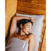 Frau liegt entspannt auf dem Badesofa Saunasofa Set Long in Nature – Wellnessmoment in der Sauna mit gepolstertem Kissen aus Waffelpiqué