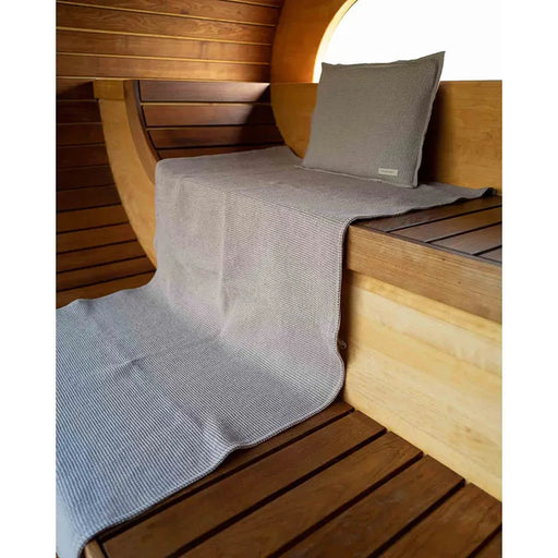 Badesofa Saunakopfkissen und ausgebreitetes Saunatuch aus Waffelpiqué in einer modernen Holzsauna