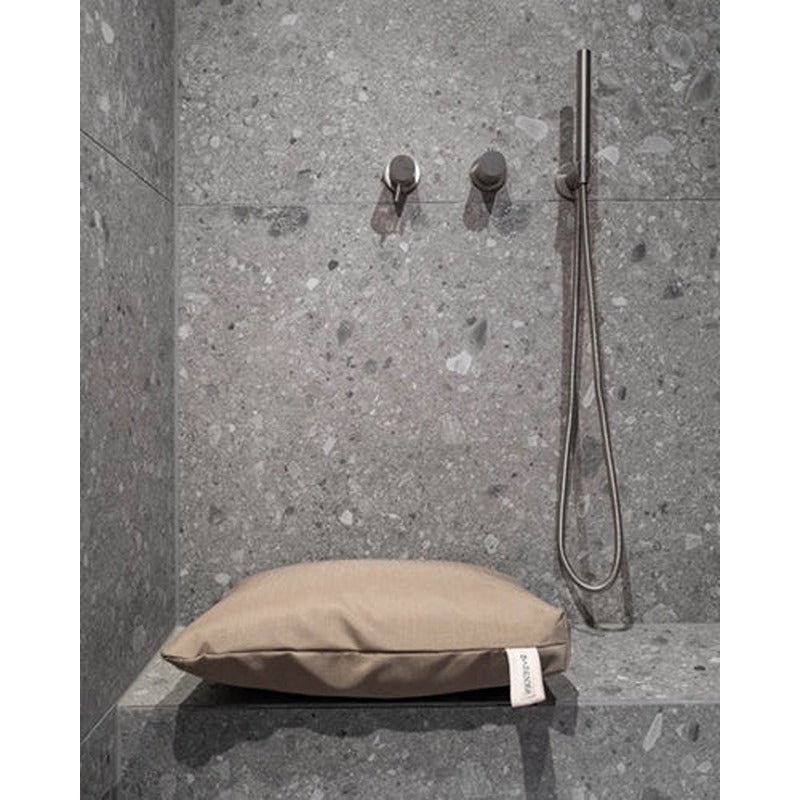 Badesofa Sitzkissen in moderner Dusche mit grauer Steinoptik und minimalistischer Handbrause.